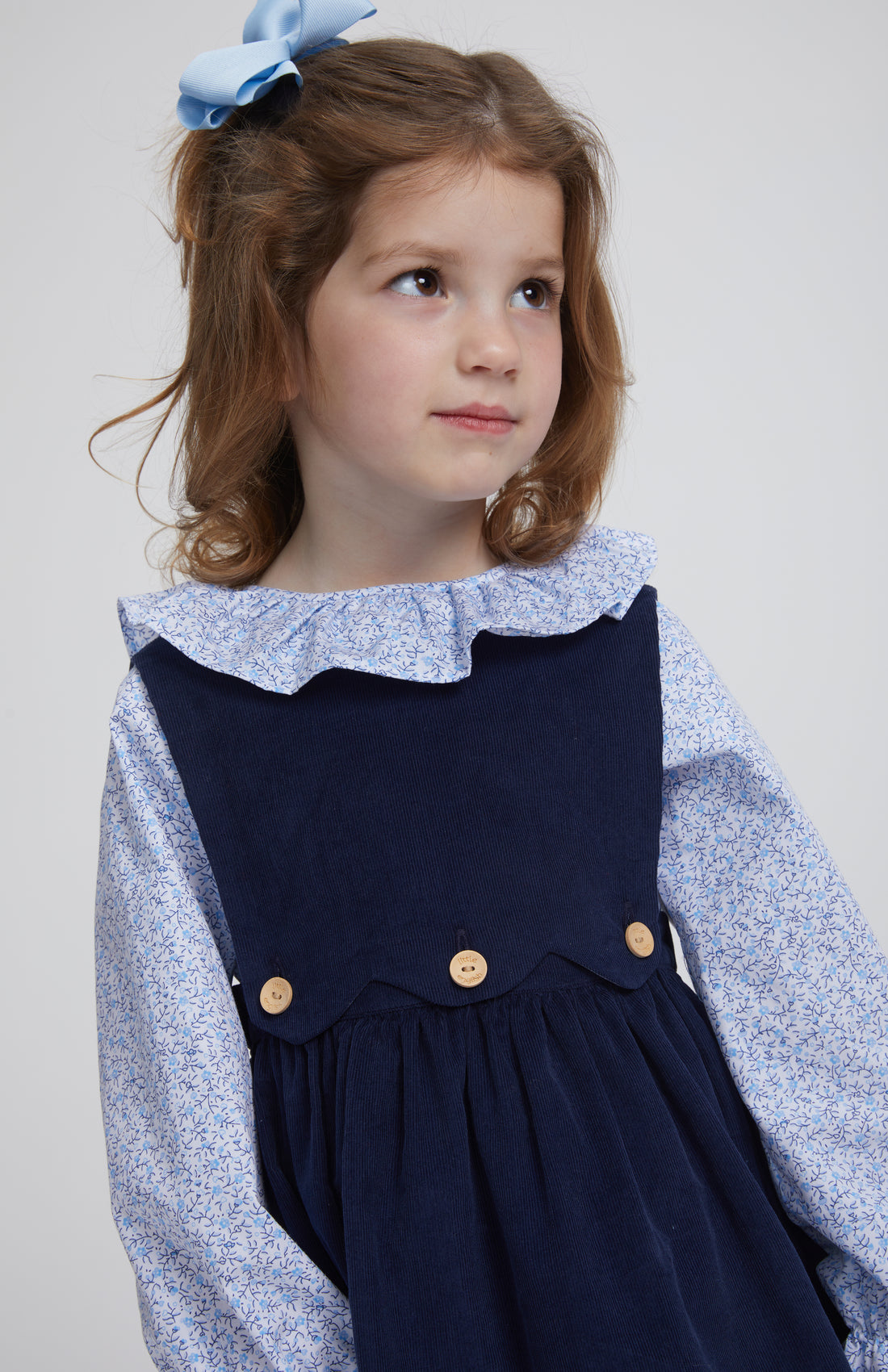 Little English traditional clothing, bespoke blouse with long sleeves in blue vinings pattern, ruffle around neck and sleeve cuffs with button panel jumper in navy corduroy