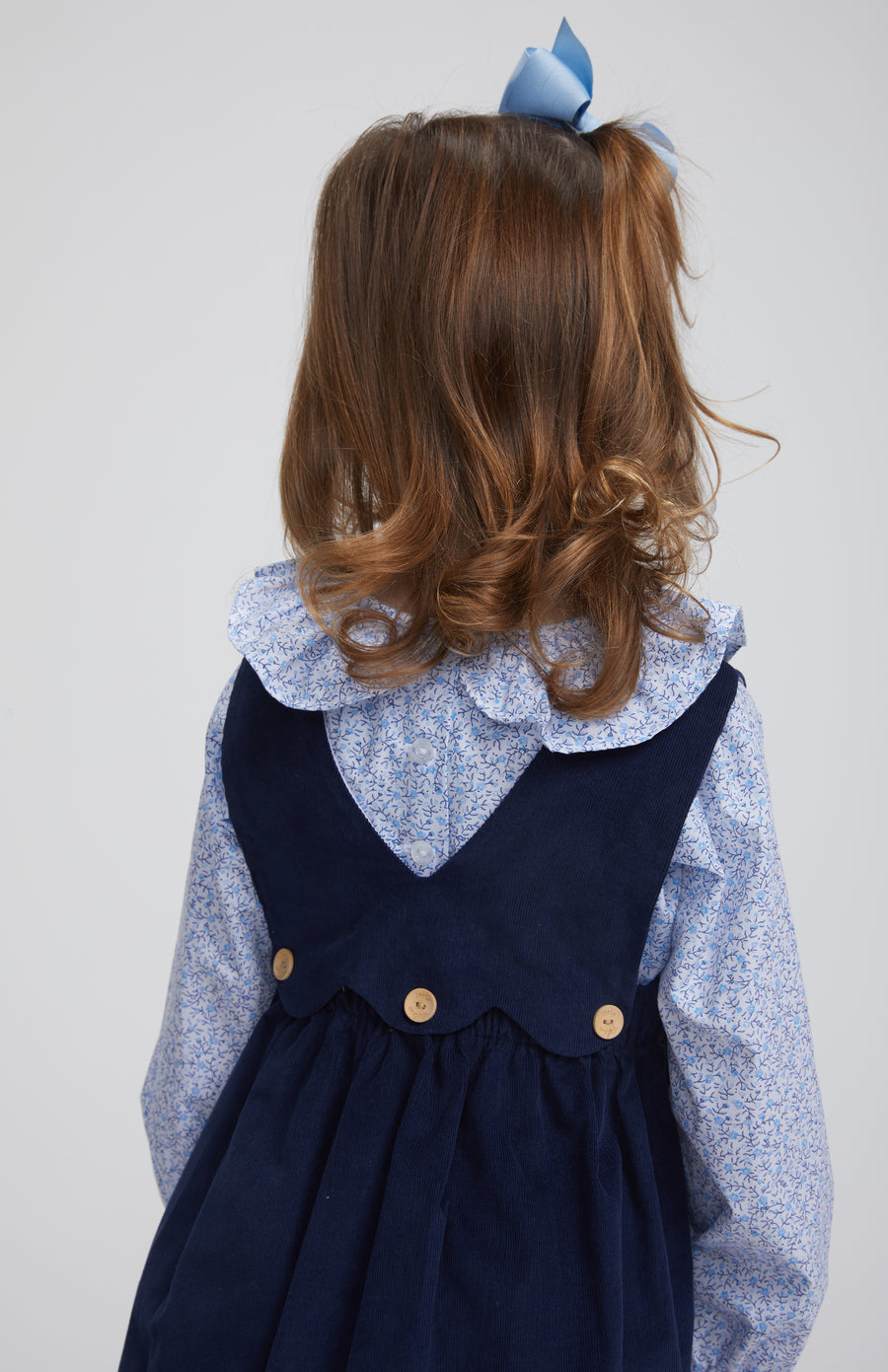 Little English traditional clothing, bespoke blouse with long sleeves in blue vinings pattern, ruffle around neck and sleeve cuffs with button panel jumper in navy, for little girl 