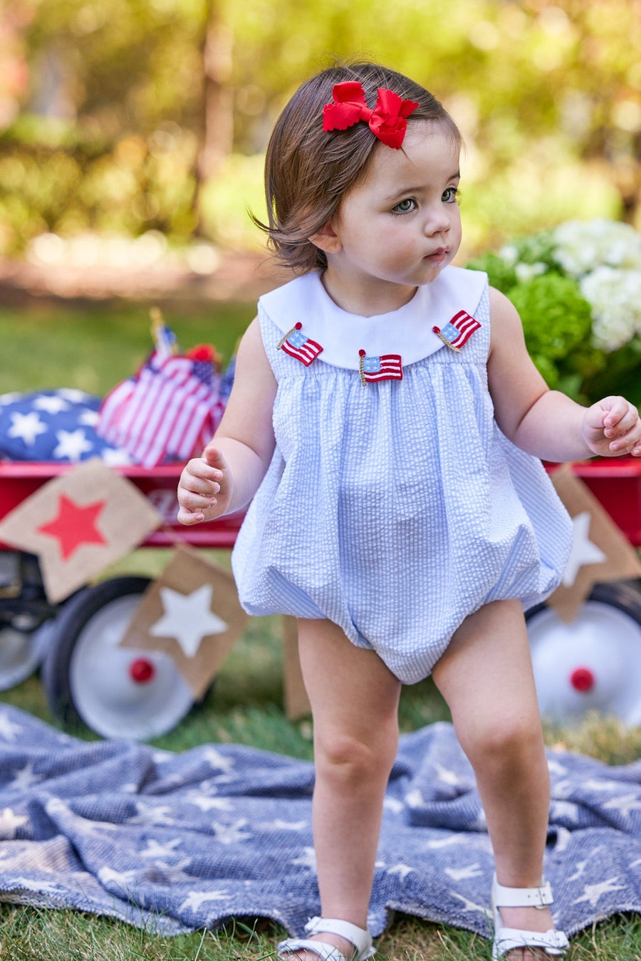 Little English traditional children's clothing. Girl's light blue and white stripe seersucker bubble with flag applique for summer.  4th of July outfit for baby girl