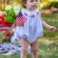 Little English traditional children's clothing. Girl's light blue and white stripe seersucker bubble with flag applique for summer.  4th of July outfit for baby girl