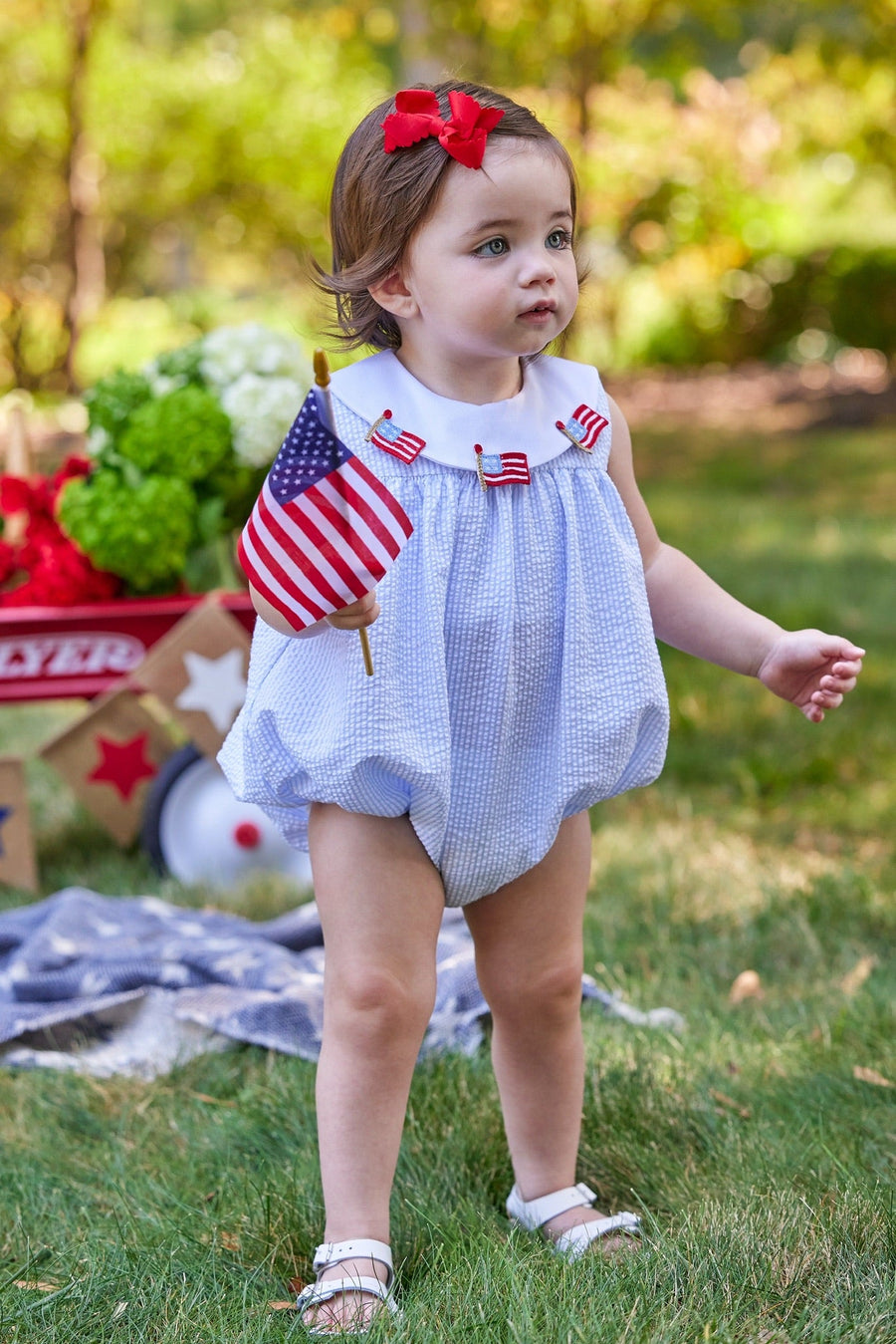 Little English traditional children's clothing. Girl's light blue and white stripe seersucker bubble with flag applique for summer.  4th of July outfit for baby girl