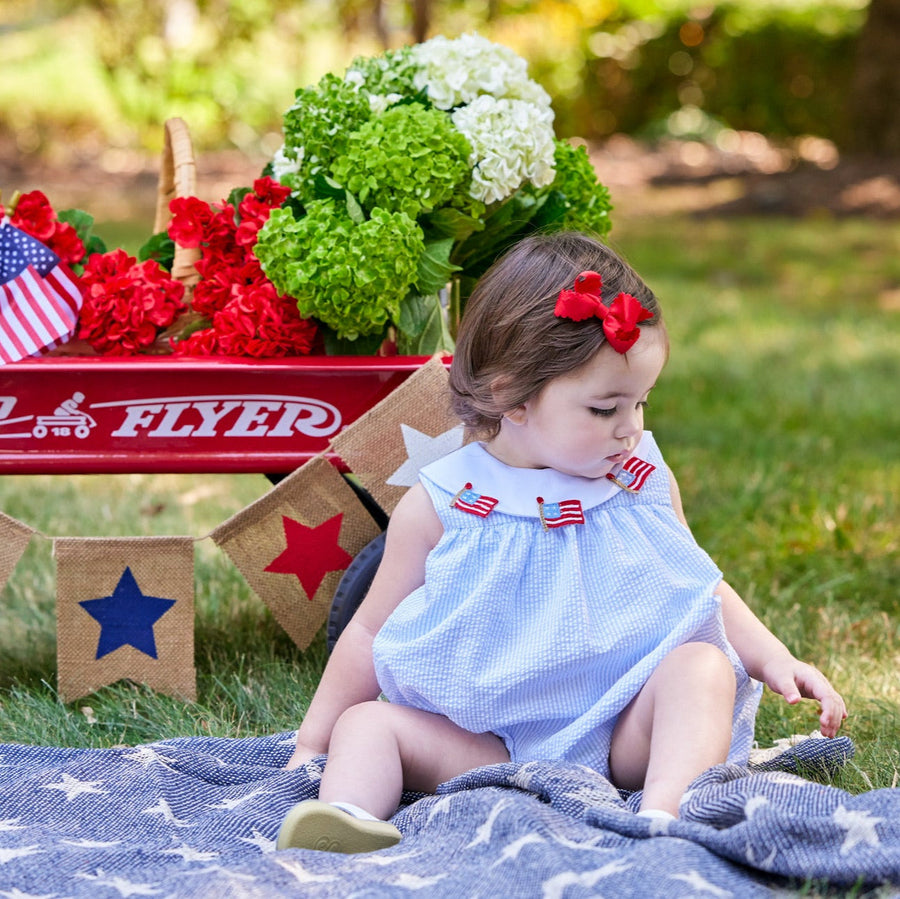 Little English traditional children's clothing. Girl's light blue and white stripe seersucker bubble with flag applique for summer.  4th of July outfit for baby girl