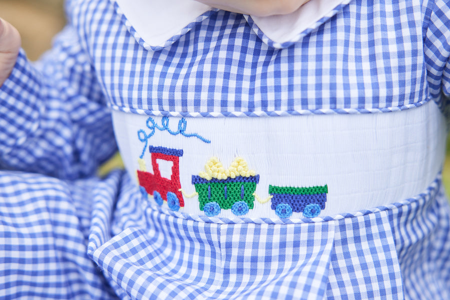 Little English traditional clothing, chest smocked romper in blue gingham pattern with embroidered train on chest for baby boy