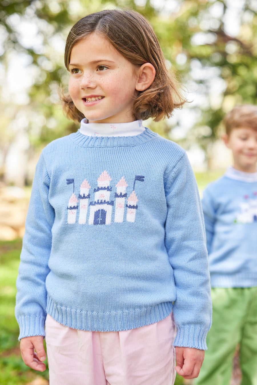 Little English traditional children's clothing. Light blue intarsia sweater with castle motif for little girl for Fall.