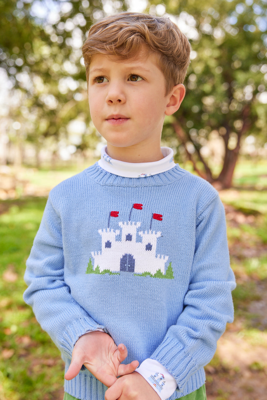 Little English traditional children's clothing. Light blue intarsia sweater with fort motif for little boy for Fall.