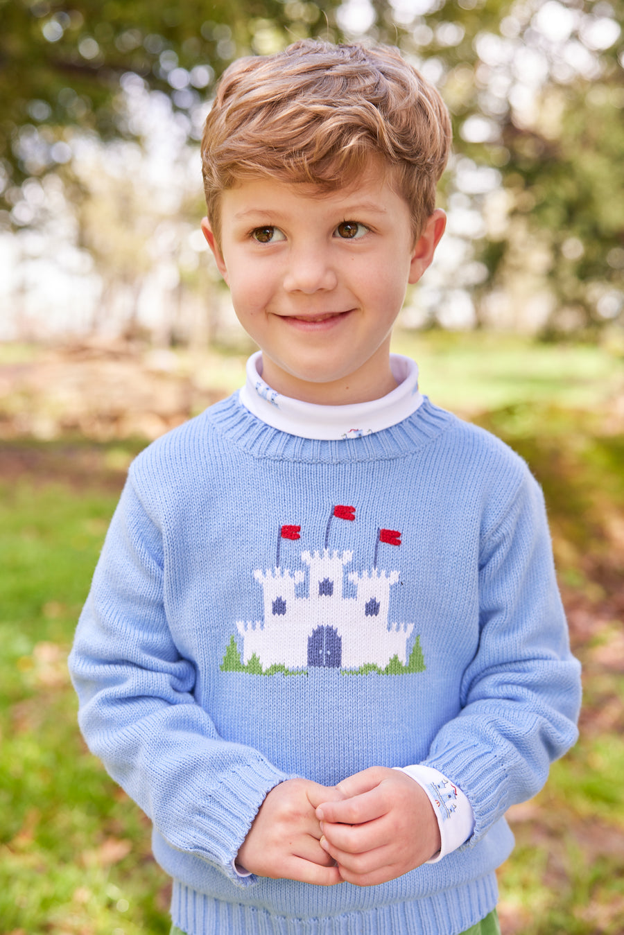 Little English traditional children's clothing. Light blue intarsia sweater with fort motif for little boy for Fall.