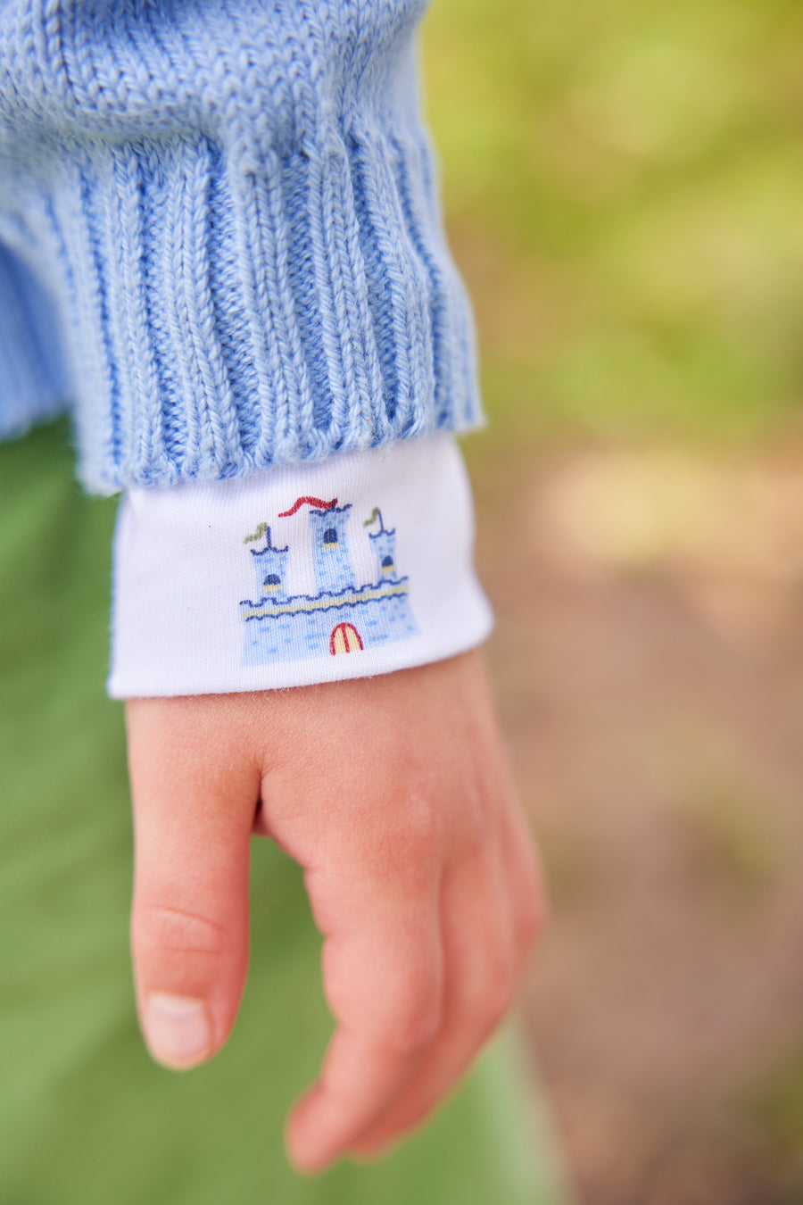 Little English traditional children's clothing. Light blue intarsia sweater with fort motif for little boy for Fall.