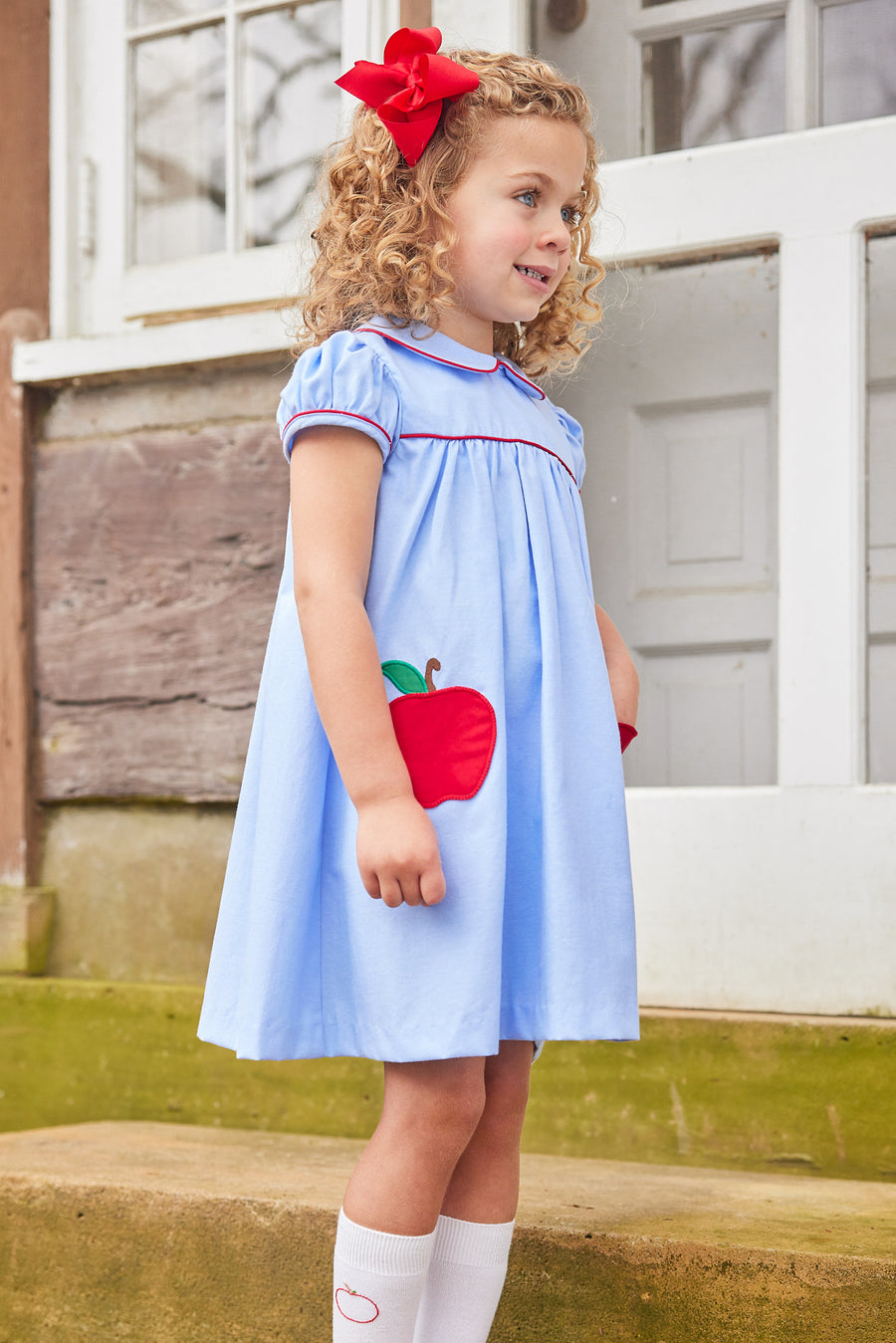 Little English traditional children's clothing. Red hair bow for girls. Classic hair accessory for Fall. Blue chambray dress for toddler girl . Back to school dress with red apple applique and red piping for fall. Paired with our apple knee high socks.