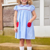 Little English traditional children's clothing. Light blue chambray dress for toddler girl . Back to school dress with red apple applique and red piping for fall. Paired with our apple knee high socks.