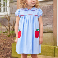 Little English traditional children's clothing. Light blue chambray dress for toddler girl . Back to school dress with red apple applique and red piping for fall.