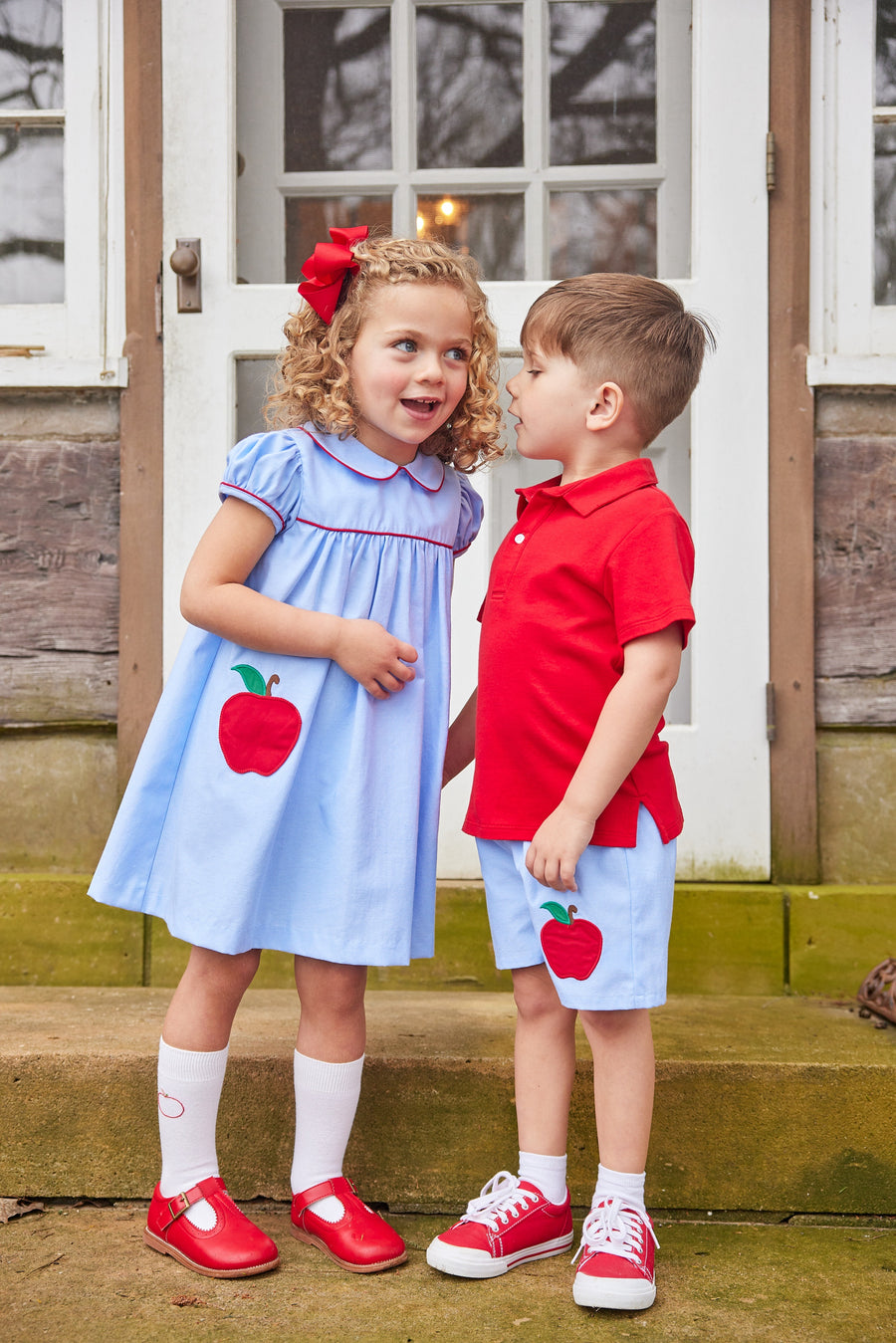 Little English traditional children's clothing. Light blue chambray basic short for little boy . Back to school shorts with red apple applique for fall. Paired with our red short sleeve polo.