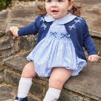 Little English traditional children's clothing. Classic smockked blue floral peter pan bubble with navy bows for little girl for Fall