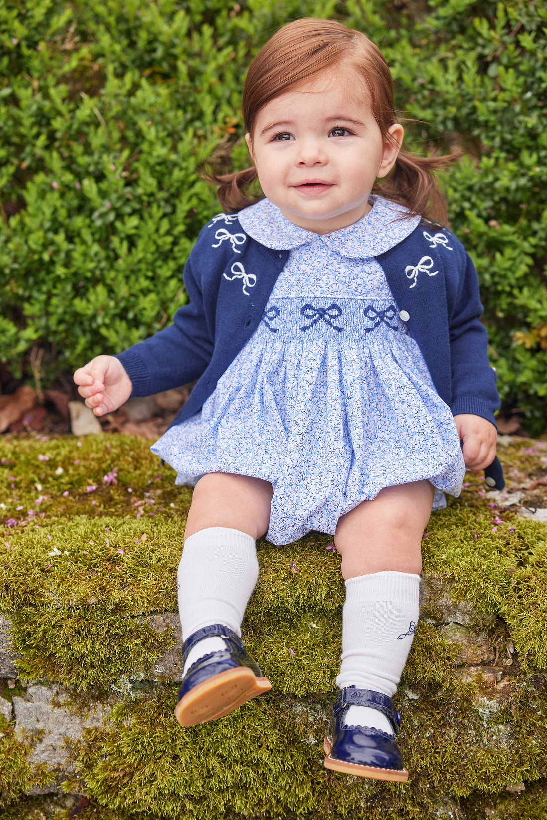 Little English traditional clothing, knit essential cardigan in navy with white bow embroidery around neckline and white buttons down the center, for little girl