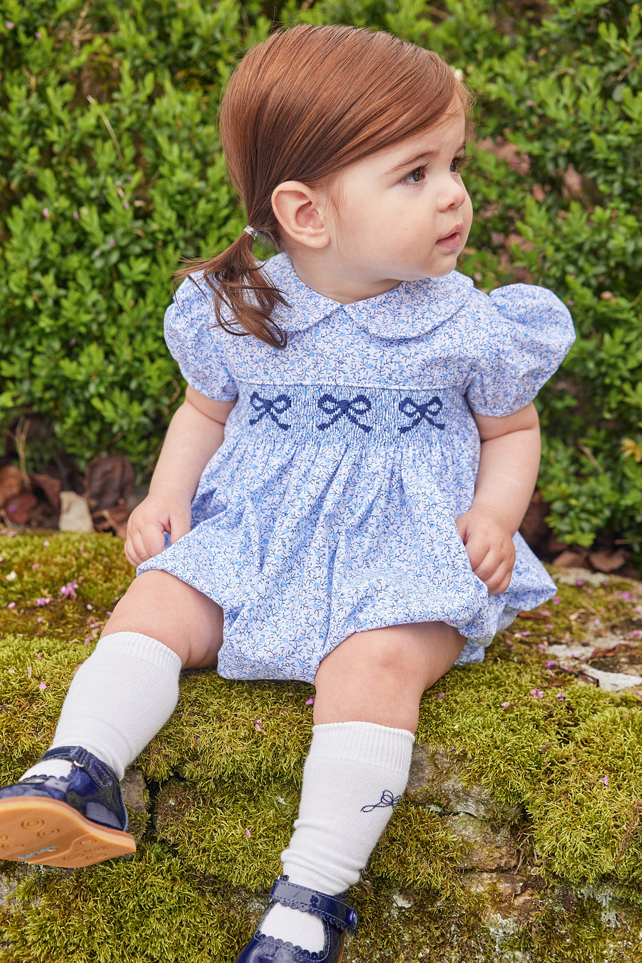 Little English traditional children's clothing. Classic smockked blue floral peter pan bubble with navy bows for little girl for Fall