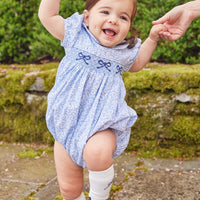 Little English traditional children's clothing. Classic smockked blue floral peter pan bubble with navy bows for little girl for Fall