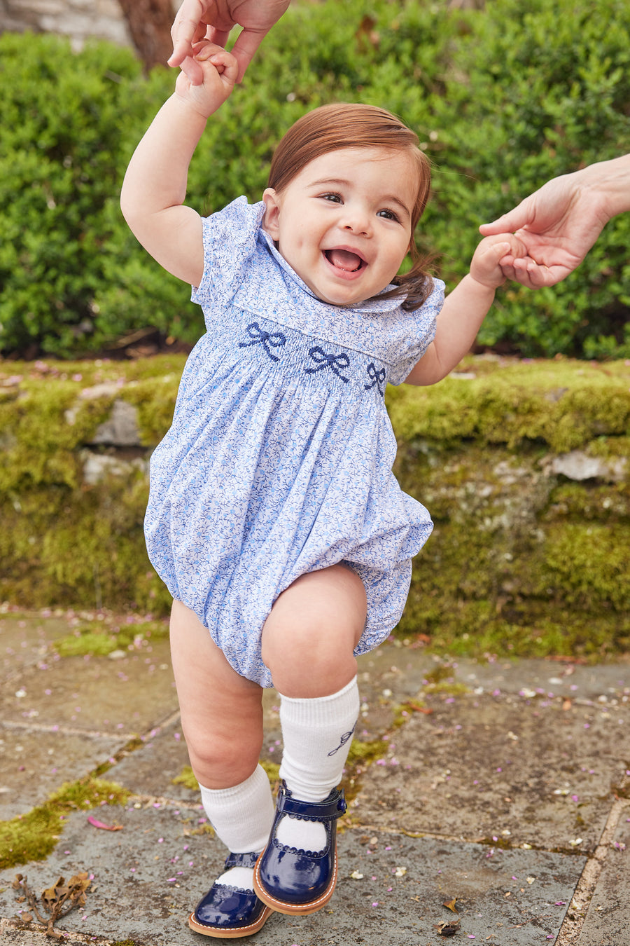 Little English traditional children's clothing. Classic smockked blue floral peter pan bubble with navy bows for little girl for Fall