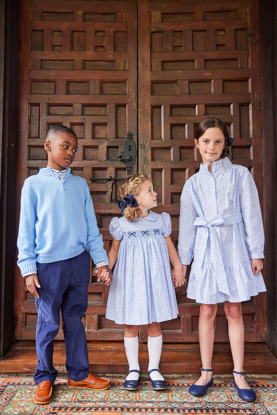 Little English traditional children's clothing. Classic smockked blue floral peter pan dress with navy bows for little girl for Fall