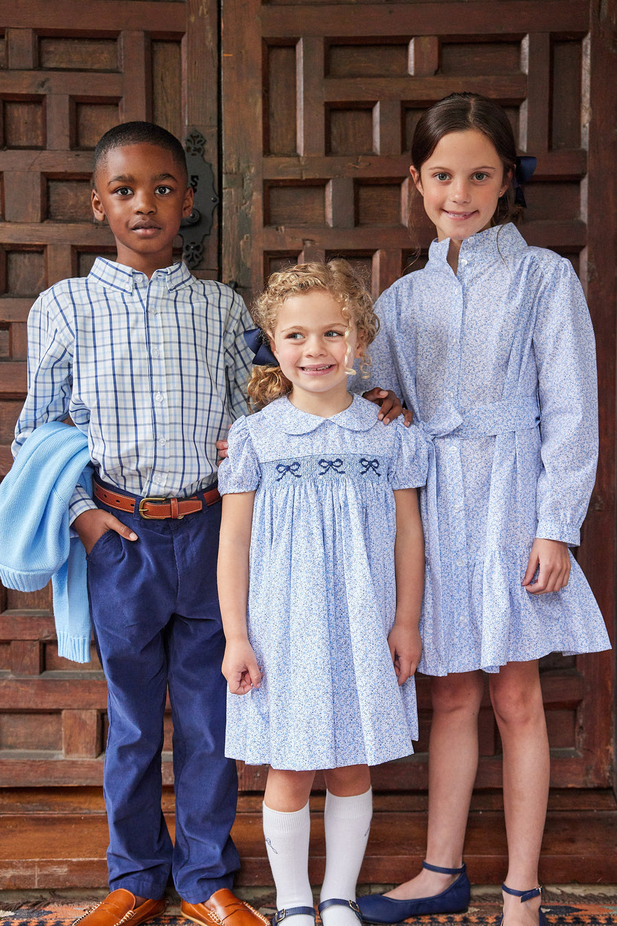 Little English traditional children's clothing. Classic smockked blue floral peter pan dress with navy bows for little girl for Fall