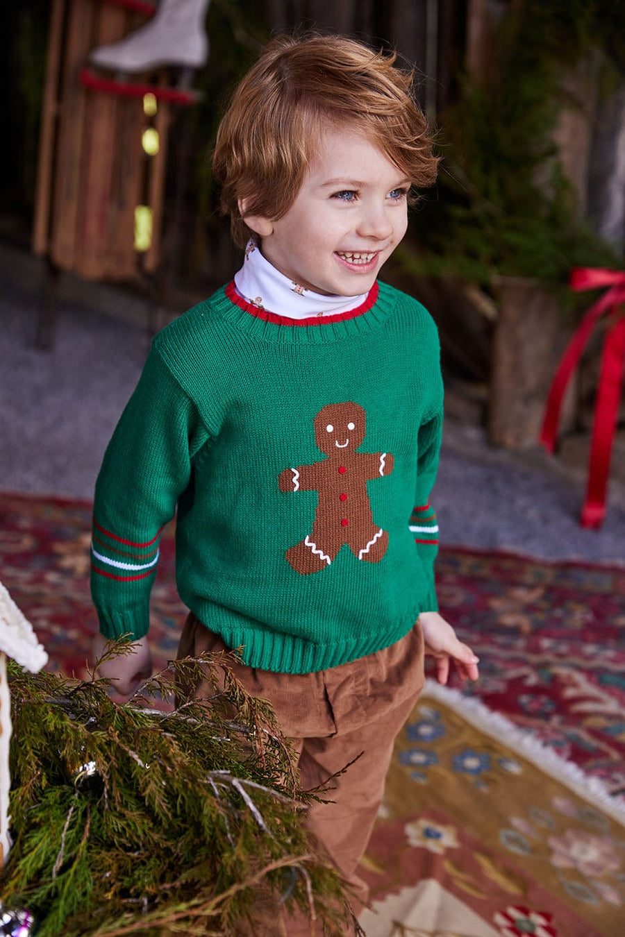 classic childrens clothing intarsia sweater in dark green with knit gingerbread man in font and red stripe on collar